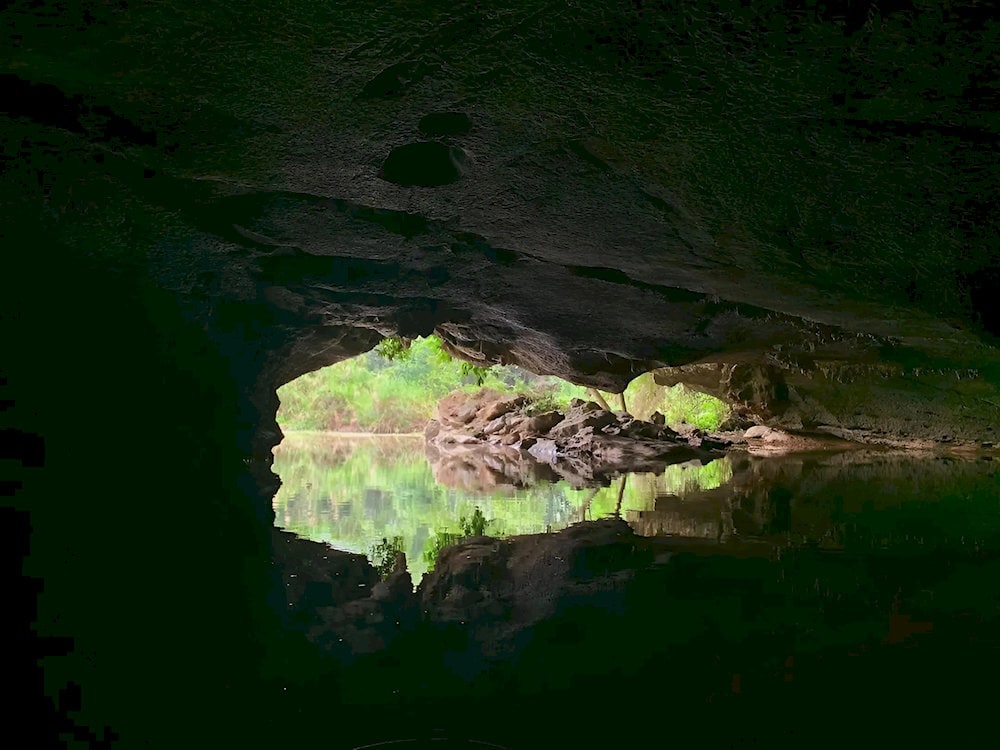 Crystal-clear water reflects shimmering light from the mystical stalactites